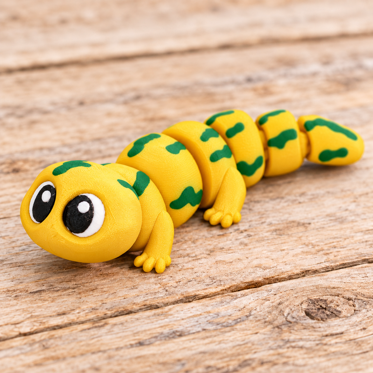 Yellow and green 3D printed Flexi Salamander on a rustic wood background
