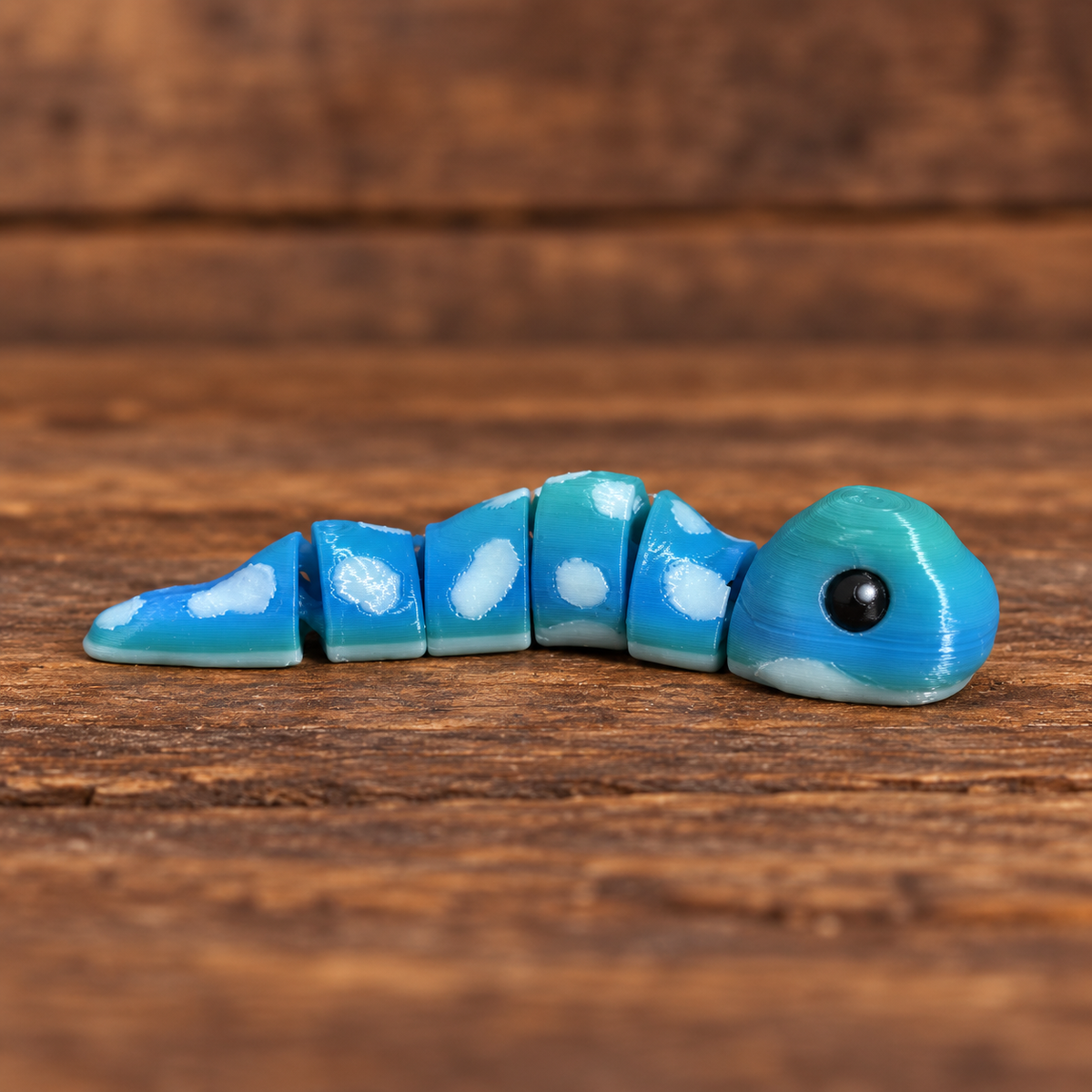 3D printed Little Critters toy on rustic wood background
