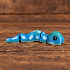 3D printed Little Critters toy on rustic wood background